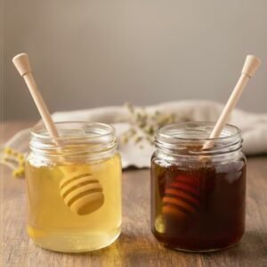 Pot de miel d'acacia à côté d'un pot de miel de châtaignier dans un décor rustique